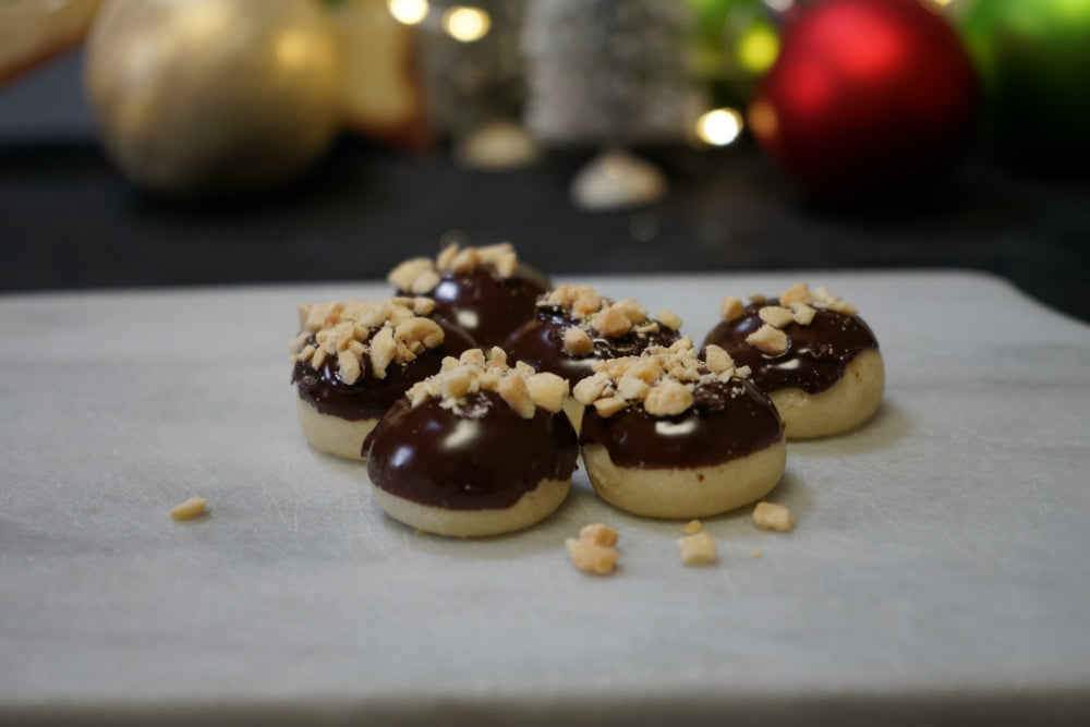 Carmel toffee Christmas cookie dipped in chocolate topped with crushed peanuts.